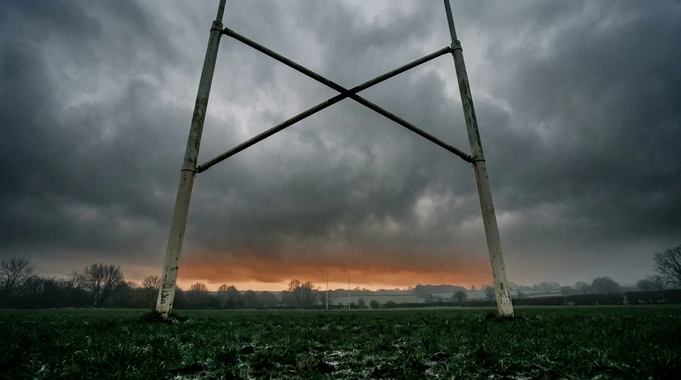 Poteaux de rugby en contre-jour au bout d'un terrain