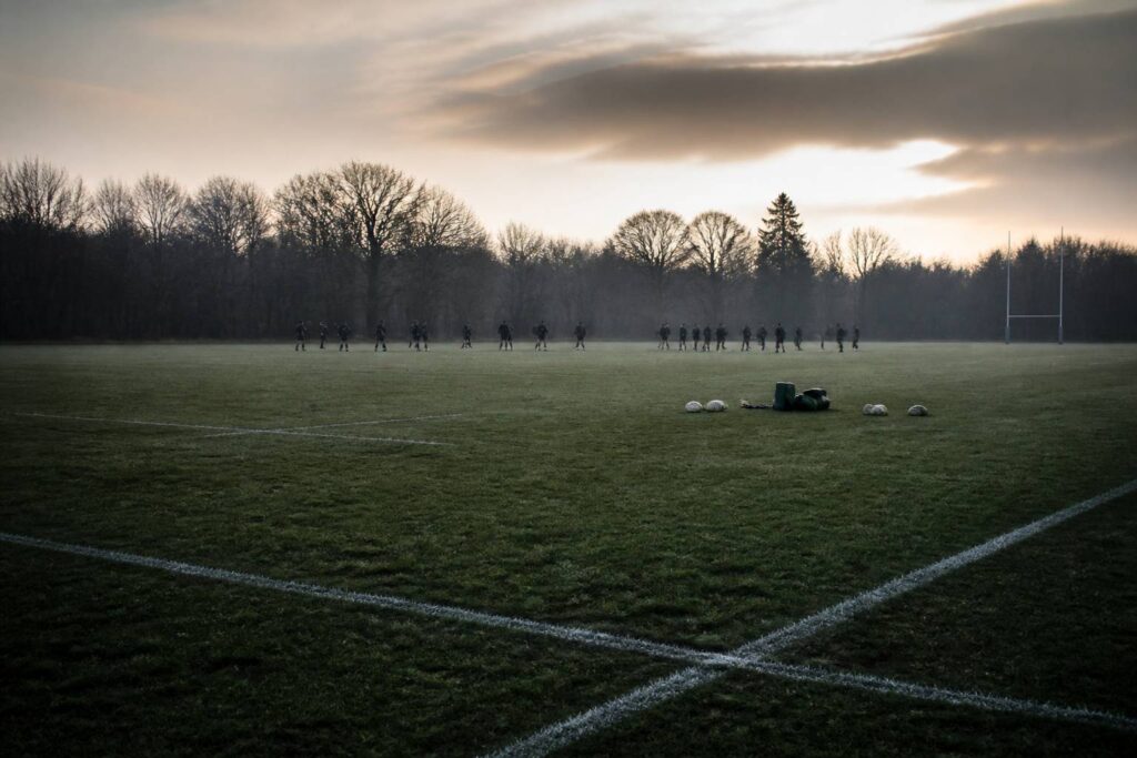 Groupe de rugbymen en tenue d'entraînement lors d'une reprise sur pelouse