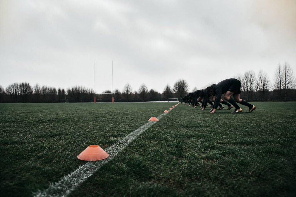 Séance de sprint sur un terrain de rugby avec des plots de départ