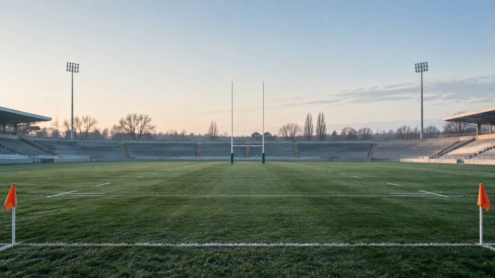 Pelouse de stade avec poteaux en H blancs et drapeaux de touche unis