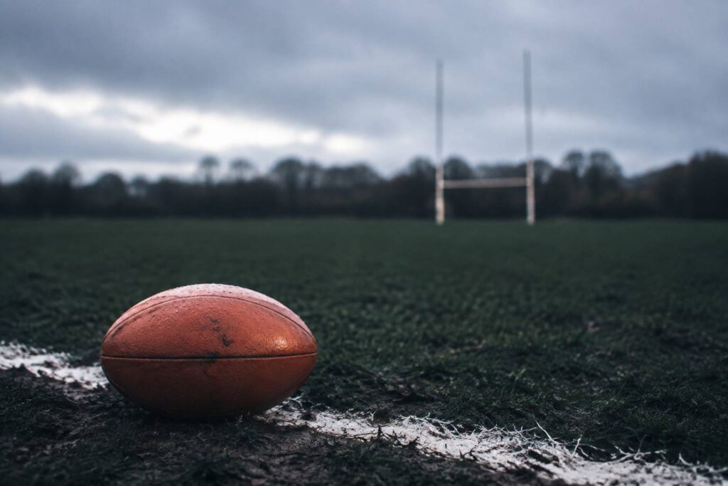 Ballon de rugby sur la ligne de craie d'un terrain d'hiver
